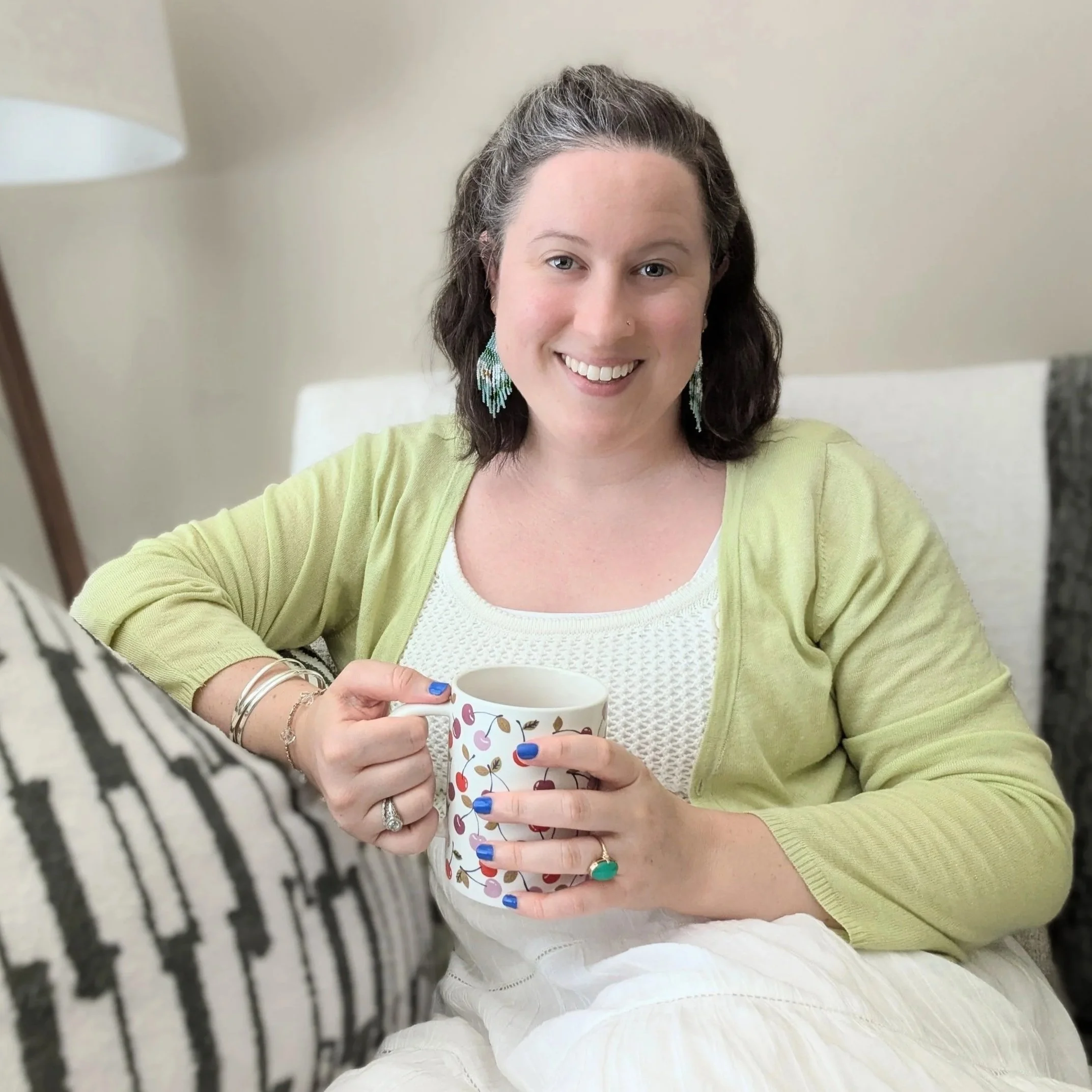 photo of female therapist holding coffee cup sitting on therapy couch
