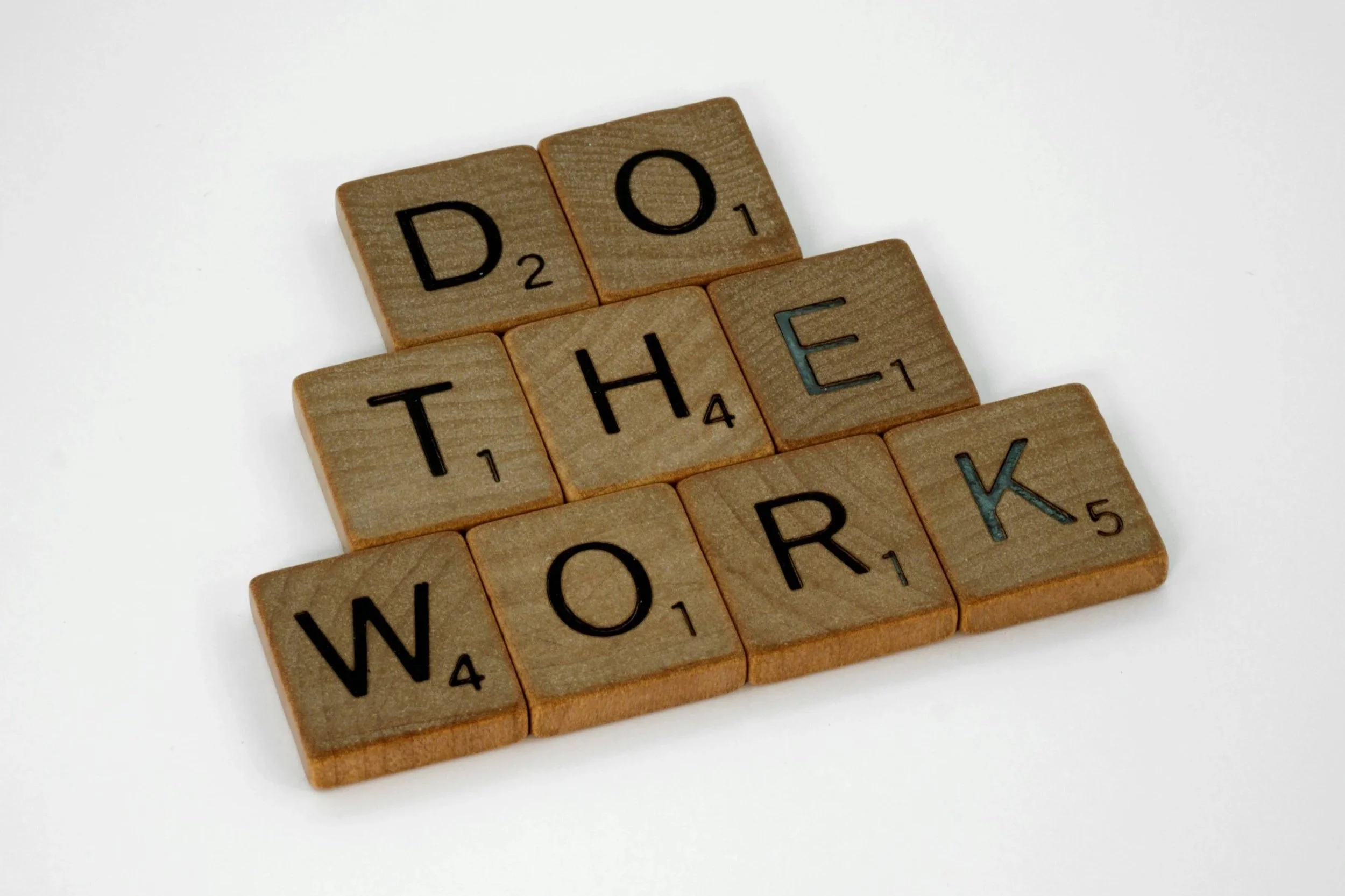 wooden scrabble tiles spelling out "do the work"