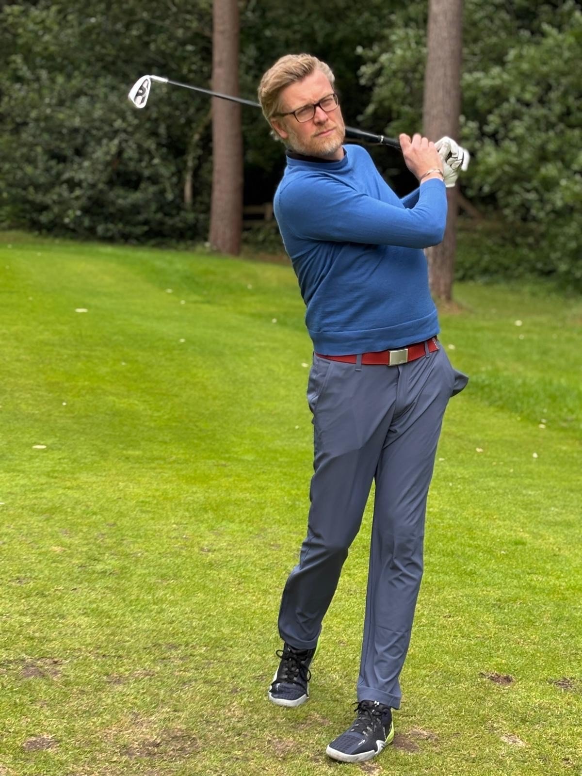 golf player swinging club at atgolf course