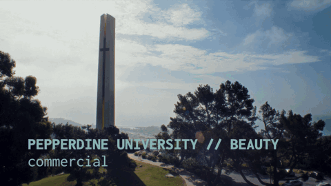 A tall, vertical cross-shaped monument with a shadow, set against a partly cloudy sky and surrounded by trees and a road, with the text 'PEPPERDINE UNIVERSITY // BEAUTY commercial' overlaid.