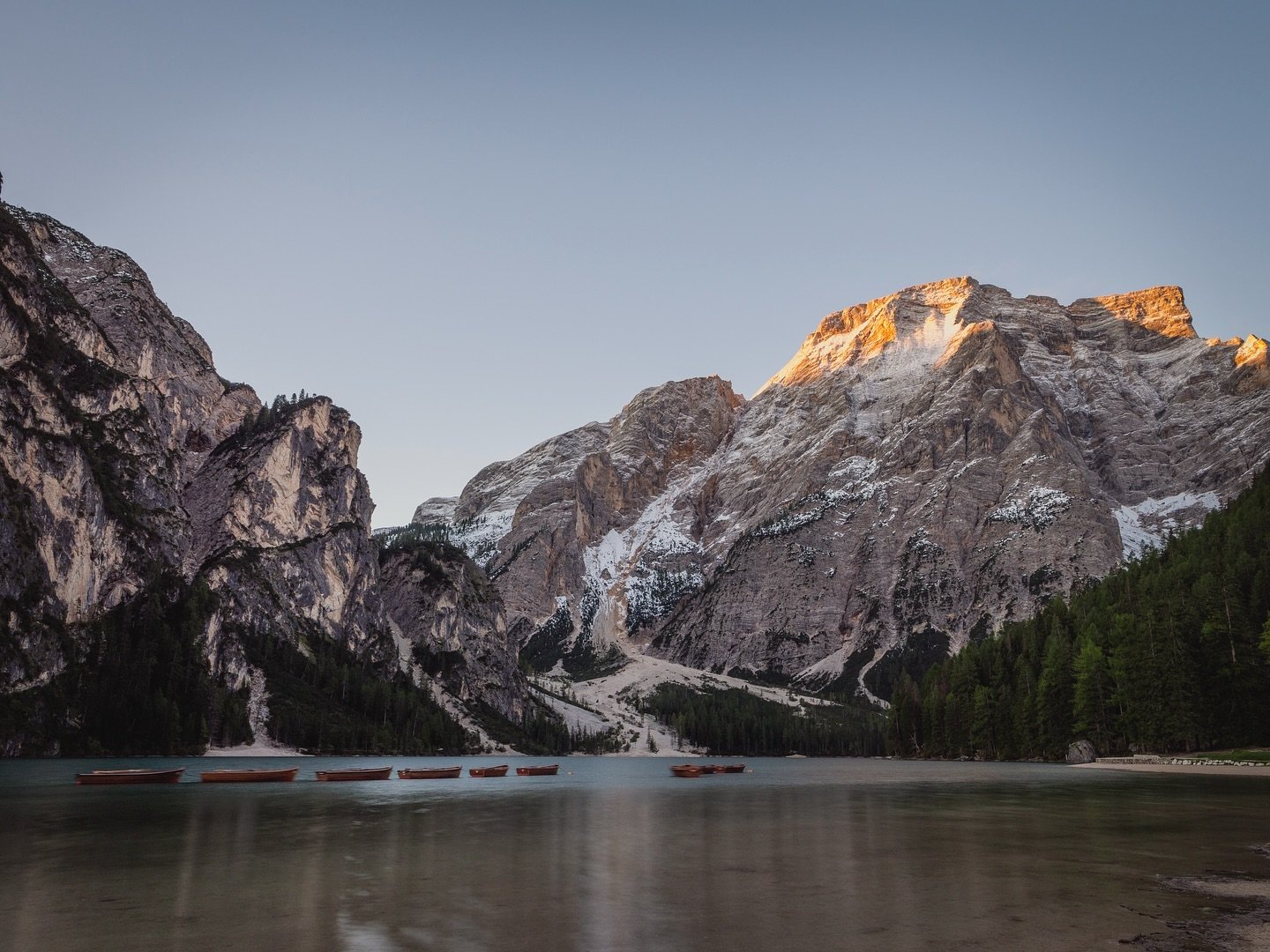Lake Braies at sunrise, Dolomites 🇮🇹 

Waking up early to watch the sun rise in the dolomites was special. Any sunrise is beautiful, but in the dolomites it glows off the mountains with a really strong orange. 

A selection of my images are now ava