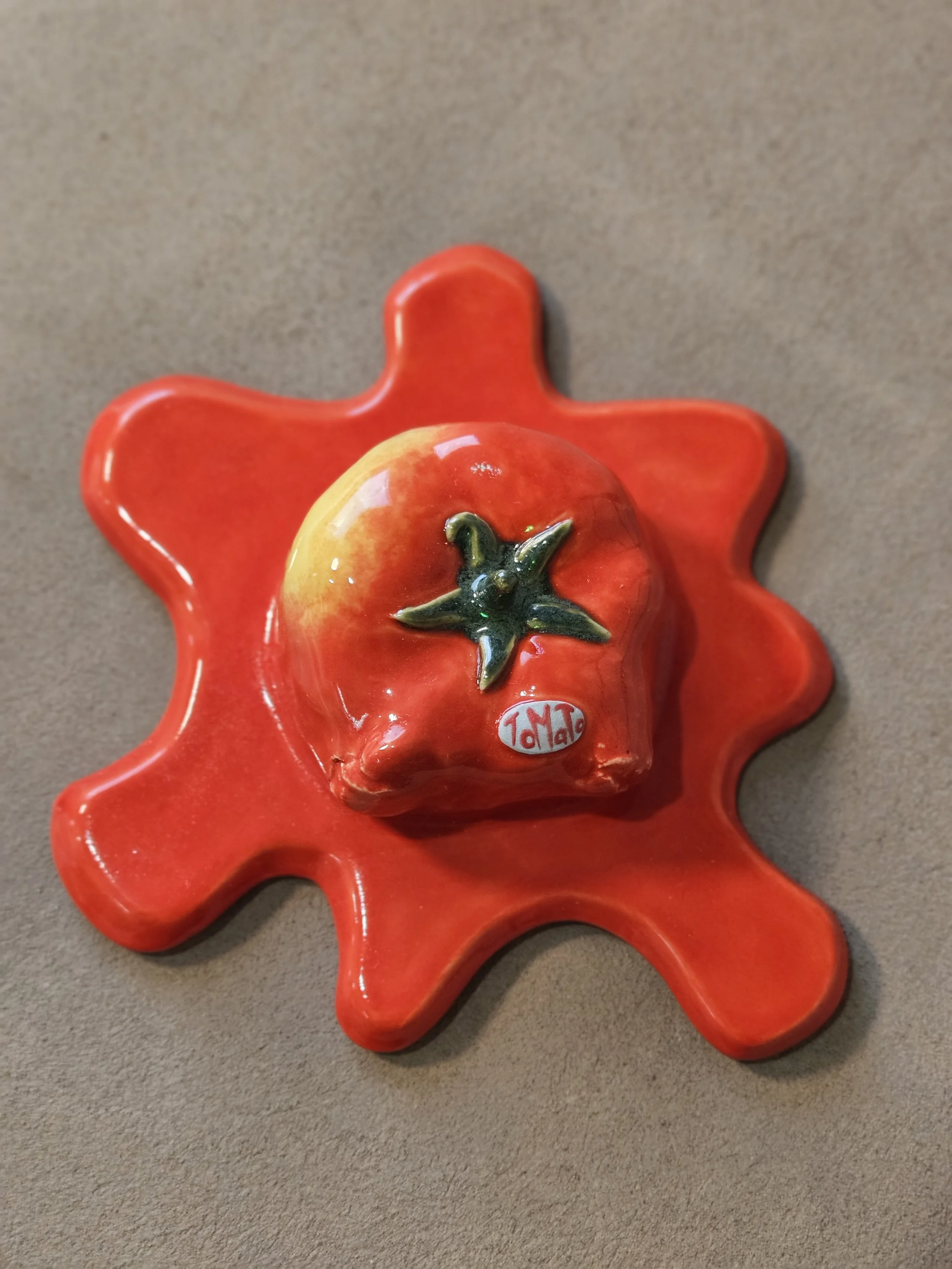 Tomato Splat is an original ceramic sculpture capturing the explosive moment a tomato hits the wall, freezing movement, frustration, and release in a single suspended form.