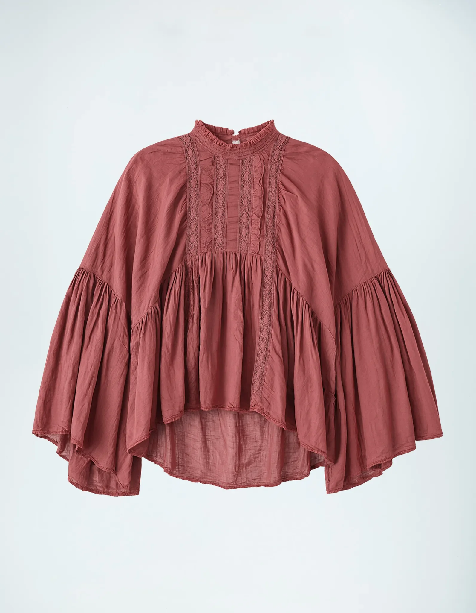 Produktfoto einer rostroten Boho-Bluse mit vertikalen Spitzenstreifen, gerafftem Kragen und ausgestellten Ärmeln auf hellem Hintergrund.