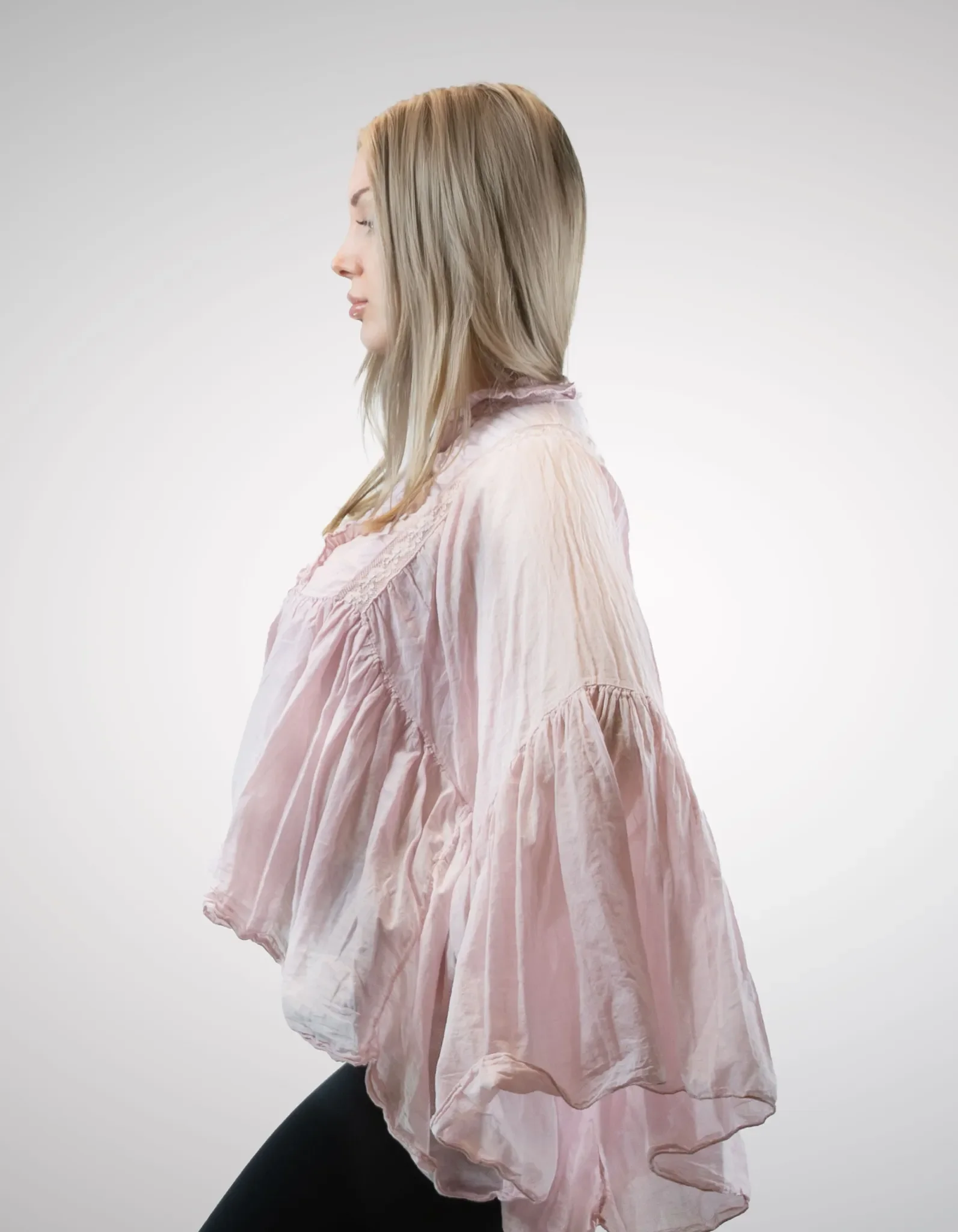 Seitenansicht der zartrosa Damenbluse im Oversize-Look, die den fließenden Stoff und das große Volumen der Ärmel optimal zeigt.
