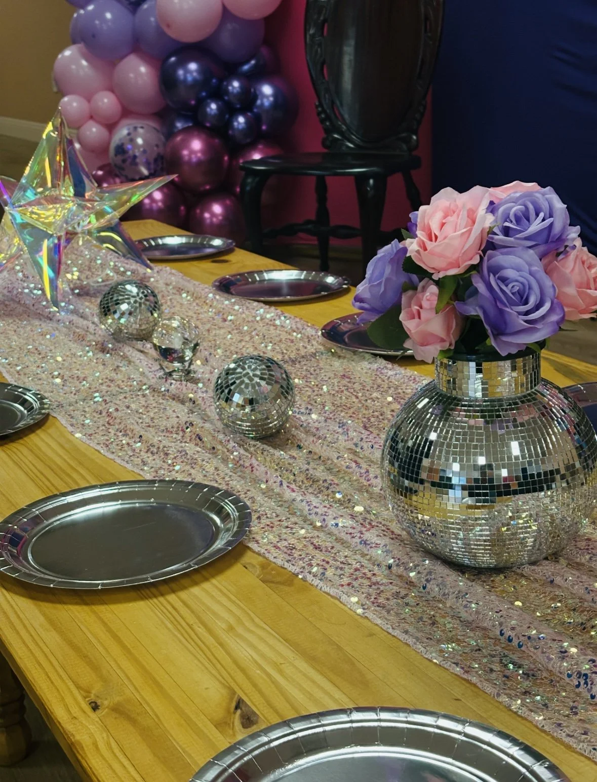 Kids birthday party décor setup with themed table styling, balloons, disco balls, and flowers at Kindred Play Collective in Orangevale.