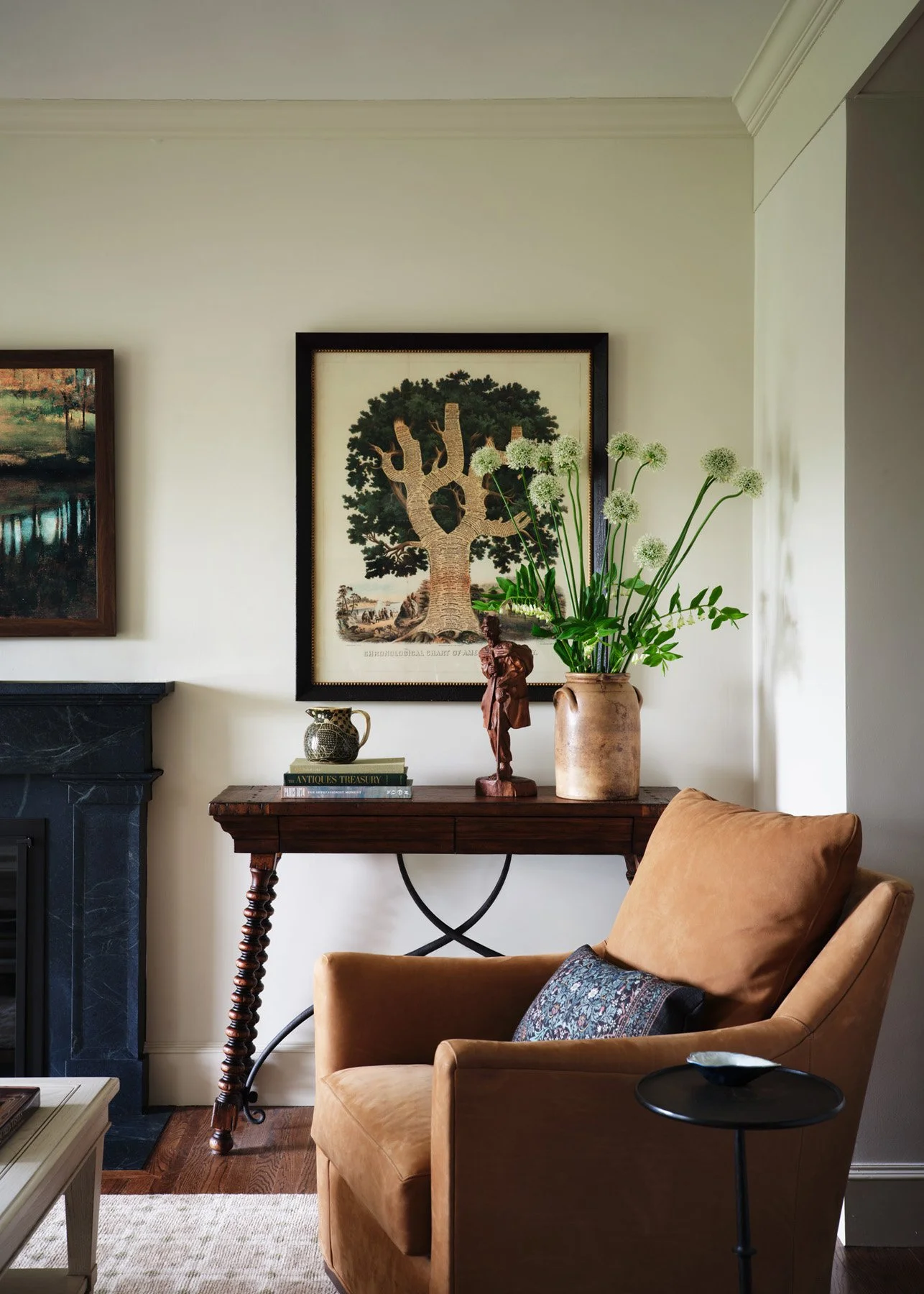 SACRIS living room with soapstone fireplace mantel, antique bobbin-leg console, framed chronological tree chart and tan leather armchair, Nashua New Hampshire