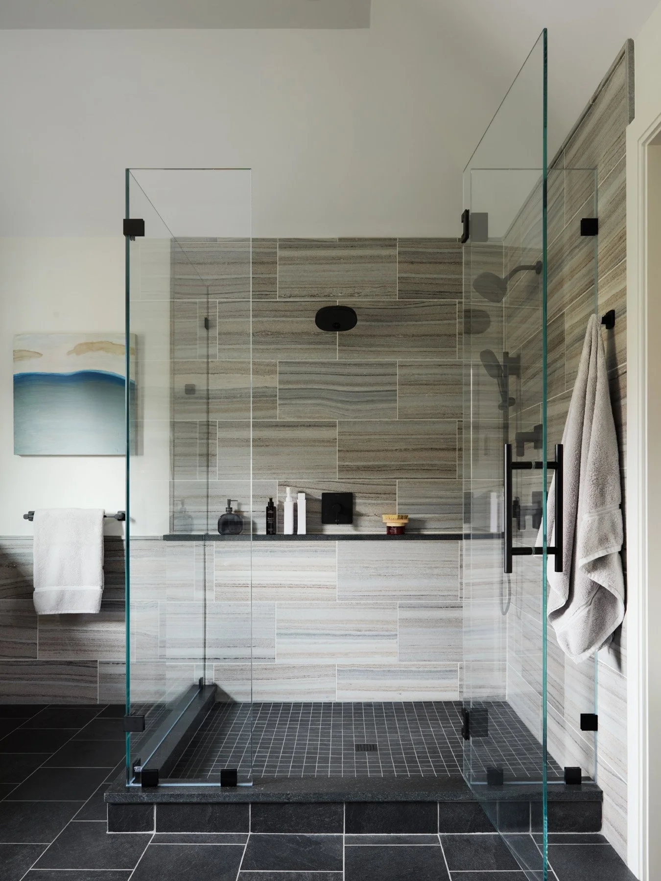 SACRIS primary bath shower with frameless glass, veined blue velvet marble tile, matte black fixtures and black tile floor, North Andover Massachusetts