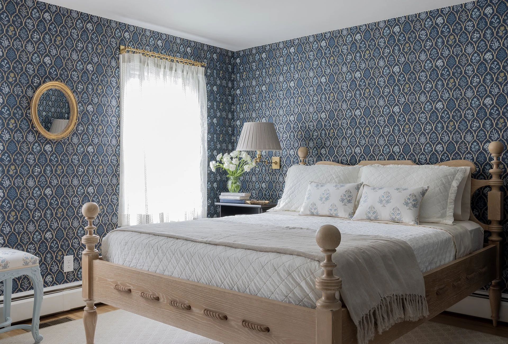 Sacris Design Newburyport Cottage primary bedroom full view with Rifle Paper navy botanical wallpaper and whitewashed cerused oak rope bed, serving Boston's North Shore
