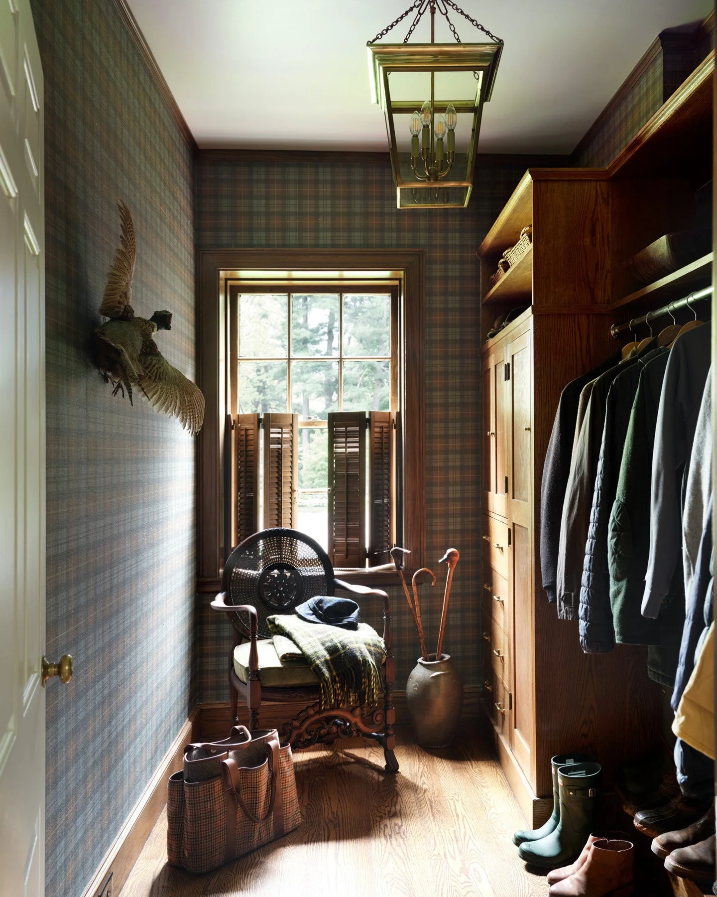 SACRIS coat room with preserved original oak cabinetry, plaid grasscloth wallcovering, brass lantern and antique caned armchair, Nashua New Hampshire
