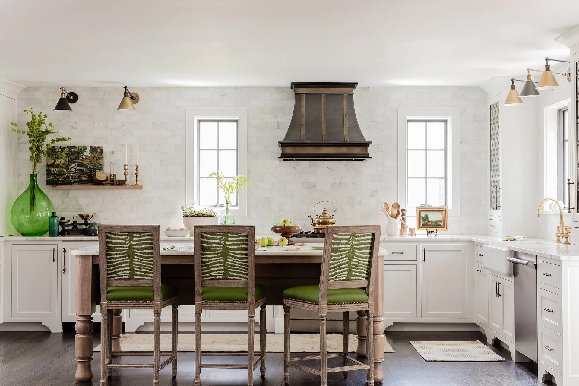 Sacris Design luxury kitchen north of Boston with custom bronze range hood, marble backsplash and green upholstered barstools