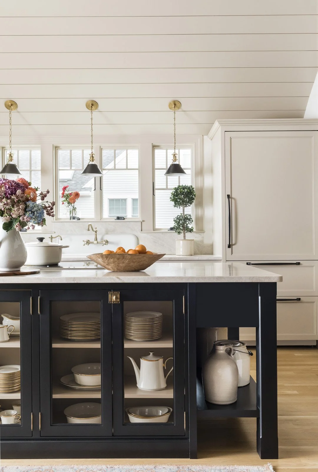 Custom black kitchen island with glass dish display and vaulted wood ceiling in Newburyport Kitchen