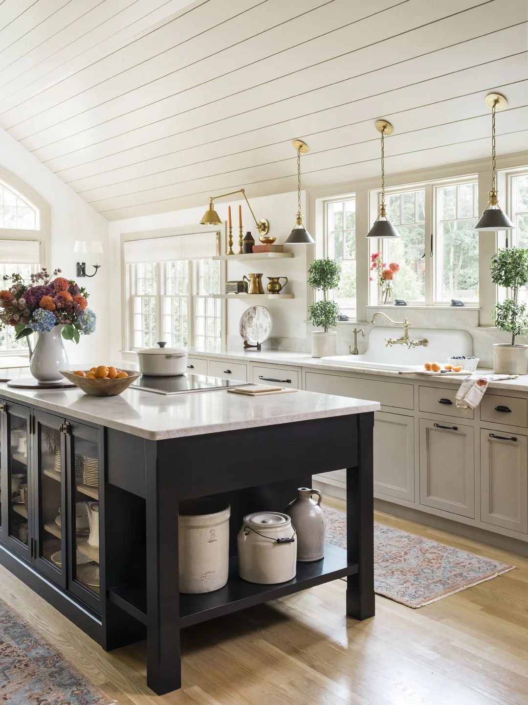 Sacris Design Newburyport Cottage kitchen with Wolf induction cooktop in black island, greige cabinetry and high back classic farmhouse sink under shiplap vaulted ceiling, Newburyport Massachusetts