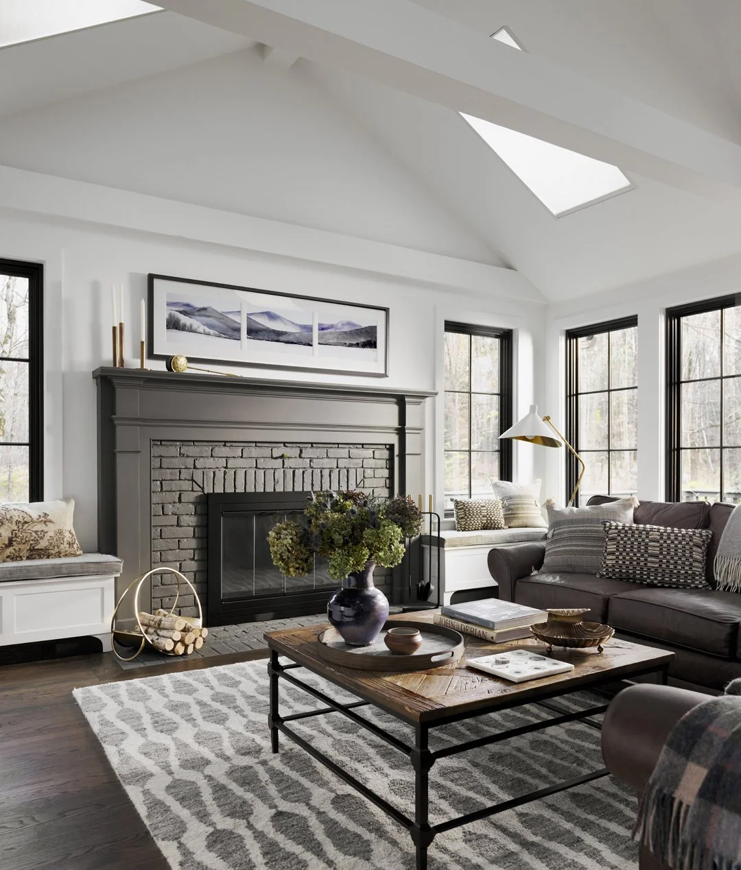 Sacris Design luxury interior design vaulted living room with skylights and dark painted brick fireplace, North Andover Massachusetts