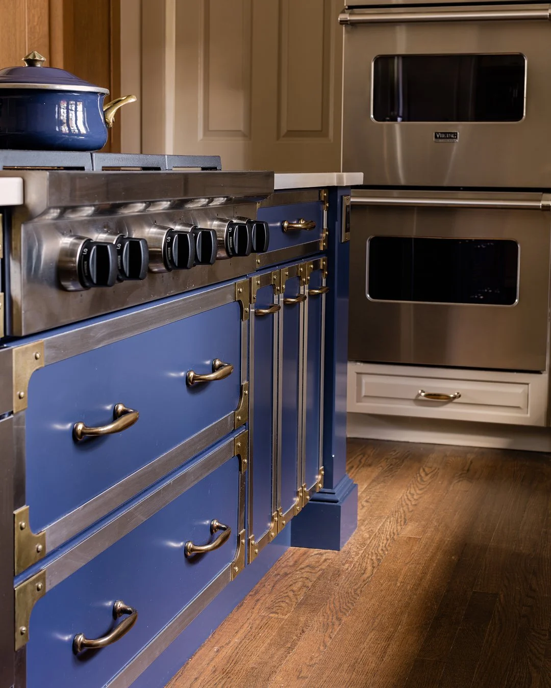 Luxury kitchen island with blue European style gas range and antique brass hardware — bespoke kitchen design in Essex County MA by Sacris Design, serving NH and Maine