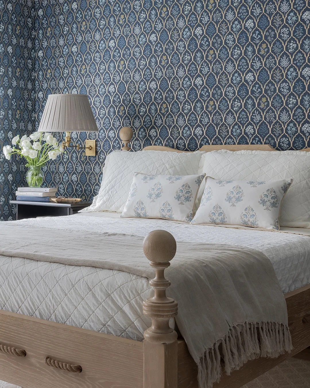 Sacris Design Newburyport Cottage primary bedroom full view with Rifle Paper navy botanical wallpaper and whitewashed cerused oak rope bed, serving Boston's North Shore