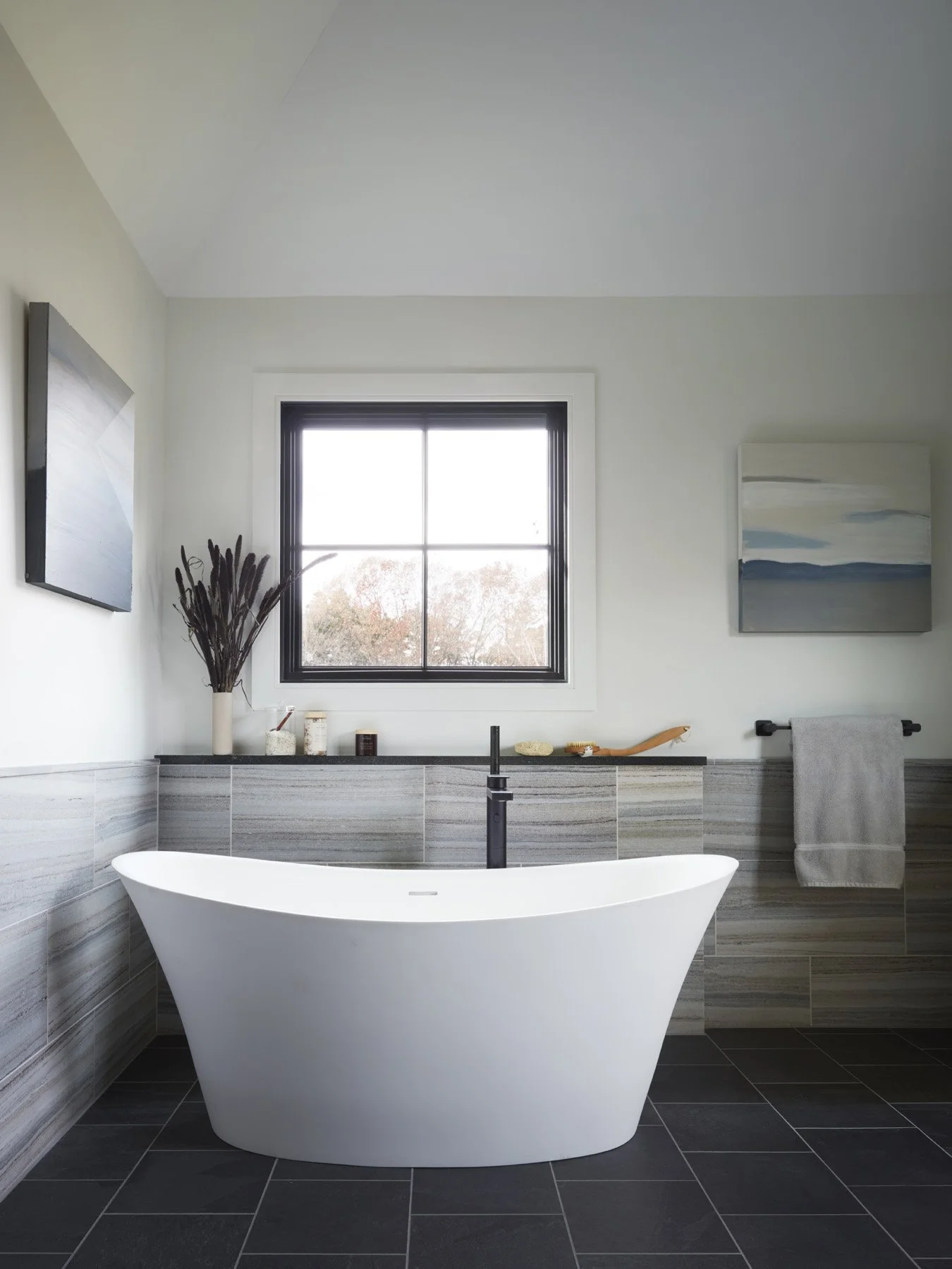 SACRIS primary bath with sculptural freestanding soaking tub, matte black floor-mount filler and veined blue velvet marble tile wainscot, North Andover Massachusetts