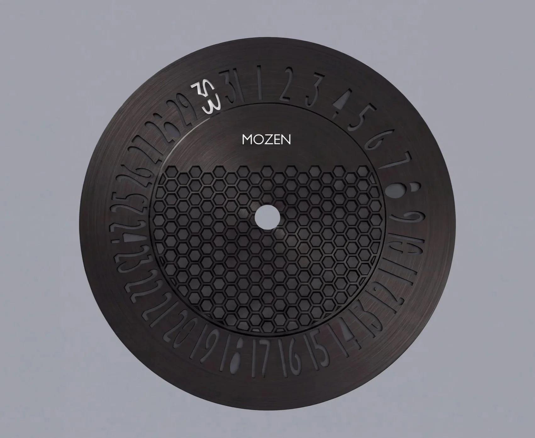 A black circular calendar with the months and days etched onto its surface, the word 'MOZEN' in the center, and a honeycomb pattern below it.