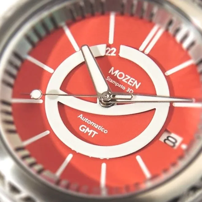 Close-up of a red Mozen wristwatch face with white and black markings, showing the time as approximately 11:52:45 with a date window at 4 o'clock.