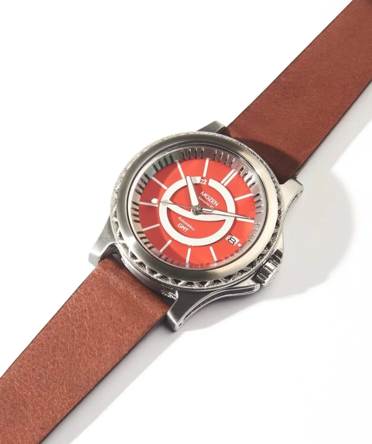 A wristwatch with a red dial, silver bezel, and brown leather strap.