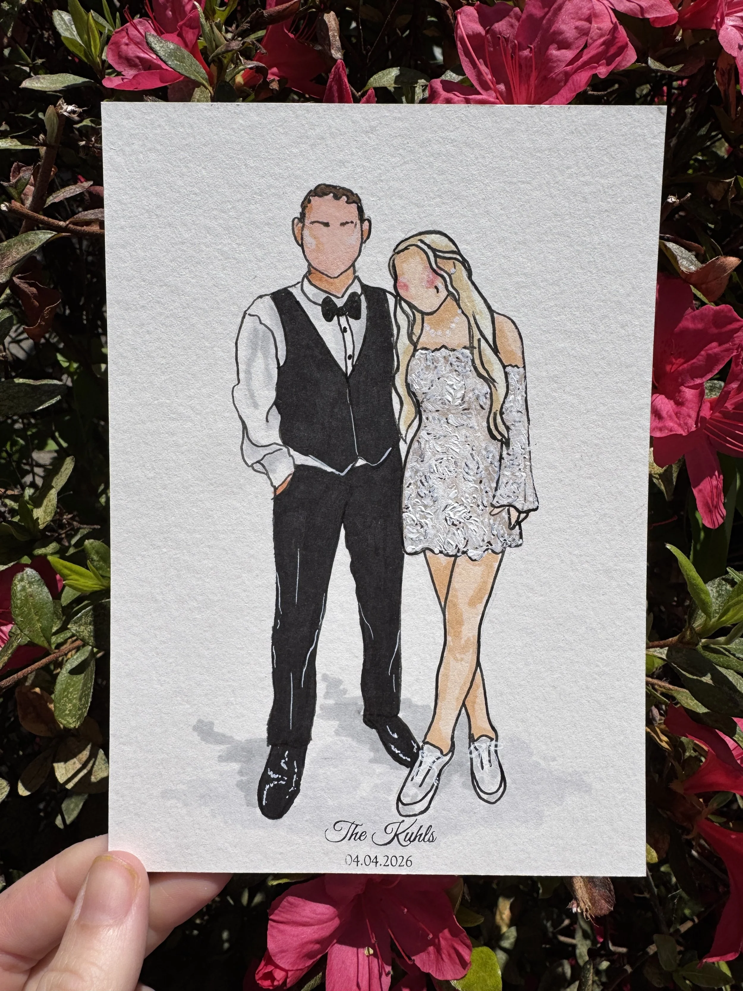 Illustration of a bride and groom in formal wedding attire. The groom is in a tuxedo, and the bride is in a lace dress with long hair. The paper has custom text "The Kuhls" and the date "04.04.2026" at the bottom.