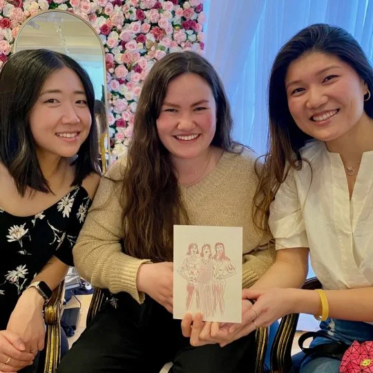 Three young women hold up their illustration created by Vignette Du Vin at RMC Wine Country