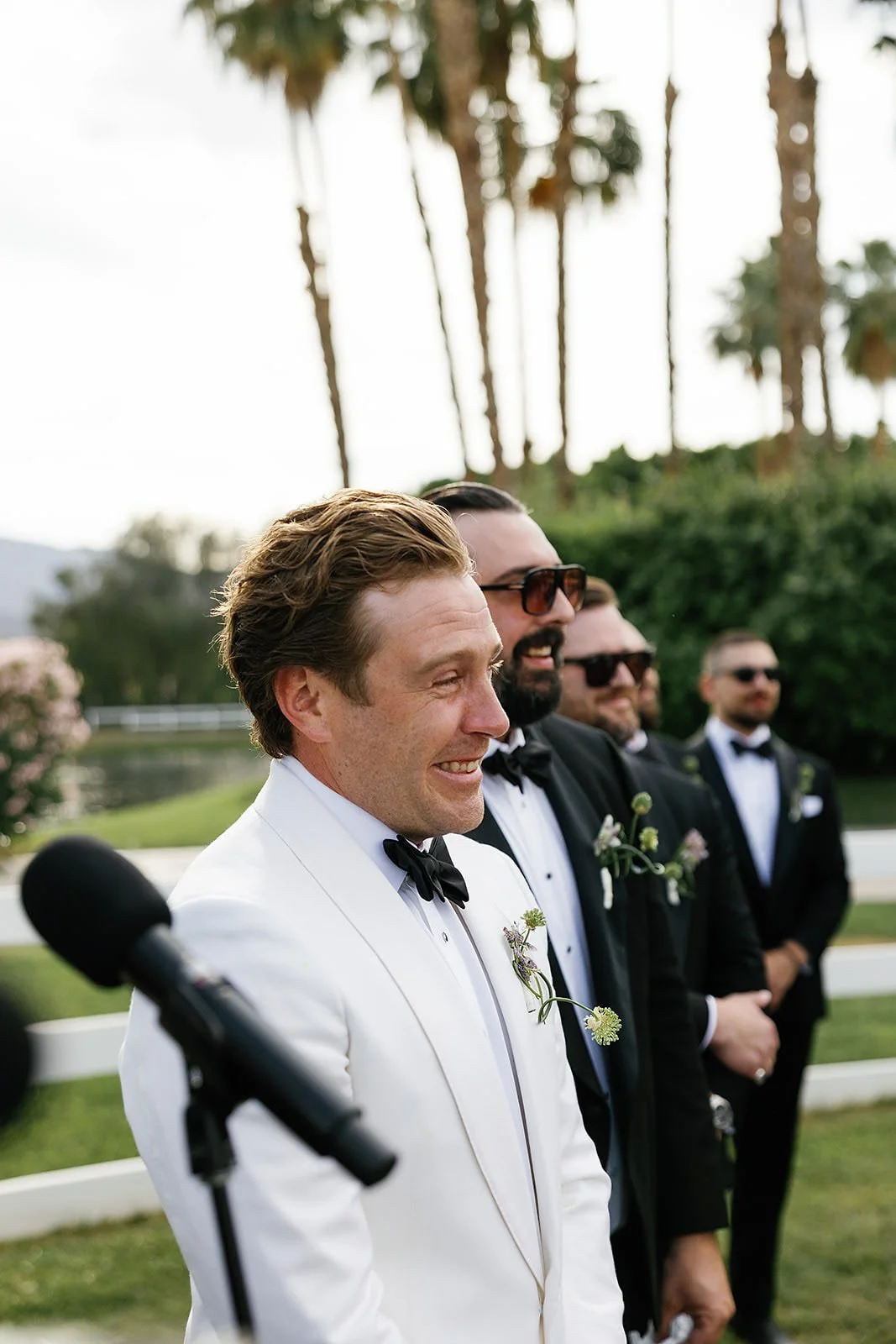 The groom crying at a Merv Griffin Estate wedding ceremony with outdoor green garden party decor designed by COJ Events