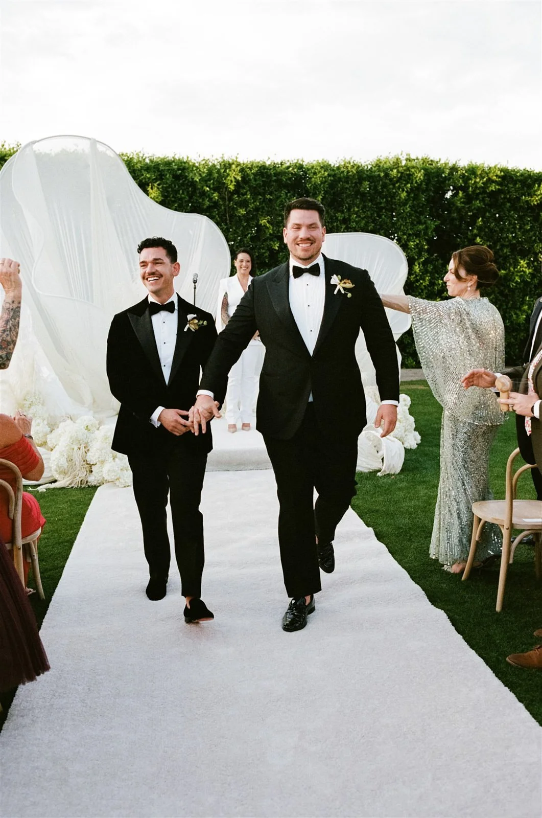 Two grooms walking up the aisle at their Cache Estate wedding ceremony in Indio, CA, by Palm Springs wedding planner COJ Events