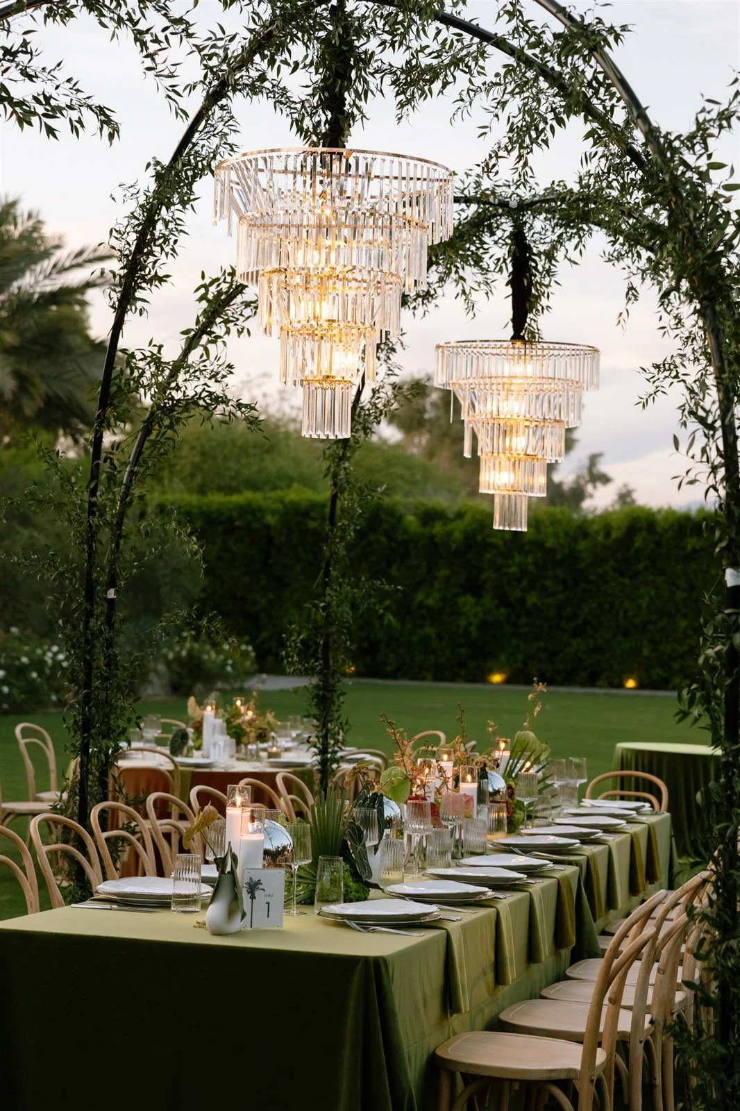 Outdoor dining tables and chandeliers at a Cache Estate wedding reception in Indio, CA, by Palm Springs wedding planner COJ Events
