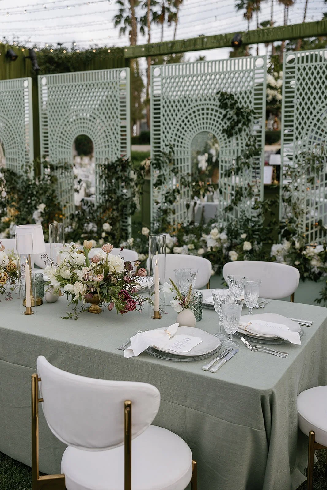 Dining tables at a Merv Griffin Estate wedding reception with outdoor green garden party decor designed by COJ Events