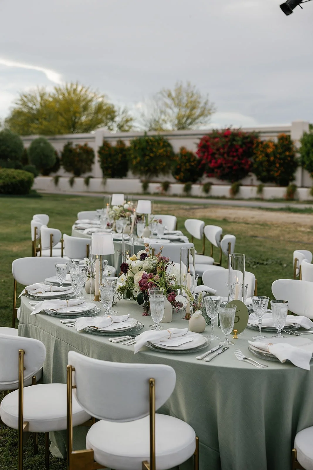 Serpentine dining tables at a Merv Griffin Estate wedding reception with outdoor green garden party decor designed by COJ Events
