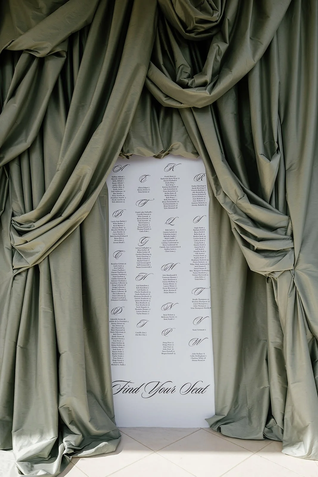 Dramatic seating chart display at a Merv Griffin Estate wedding reception with outdoor green garden party decor designed by COJ Events
