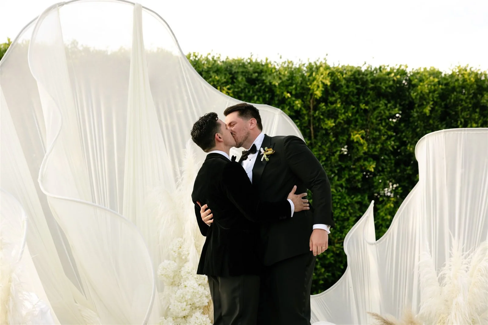 Two grooms first kiss during their Cache Estate wedding ceremony in Indio, CA, by Palm Springs wedding planner COJ Events