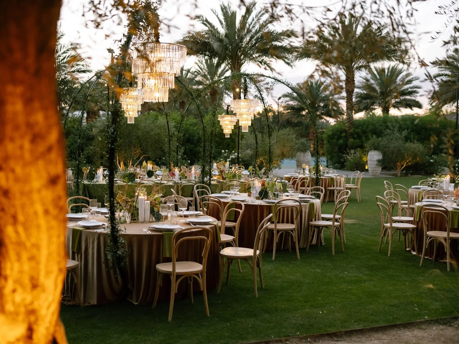 Outdoor dining tables and chandeliers at a Cache Estate wedding reception in Indio, CA, by Palm Springs wedding planner COJ Events