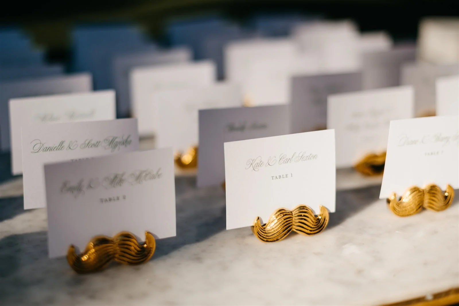 Couple's custom table cards in gold mustache holders-Designed by COJ Events-Palm Springs Destination Wedding