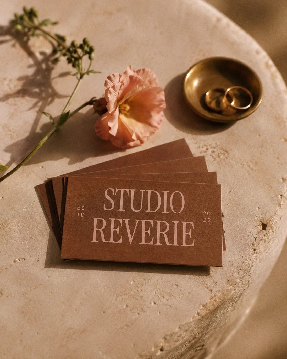Vintage-inspired beauty studio business cards styled on stone with a flower and rings