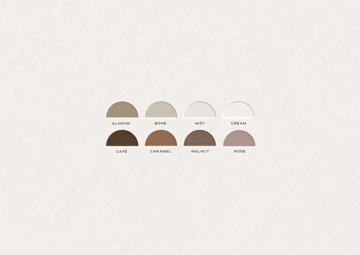 Eight embossed half-circle swatches in neutral tones, from Almond and Cream to Café, Walnut, and Rose