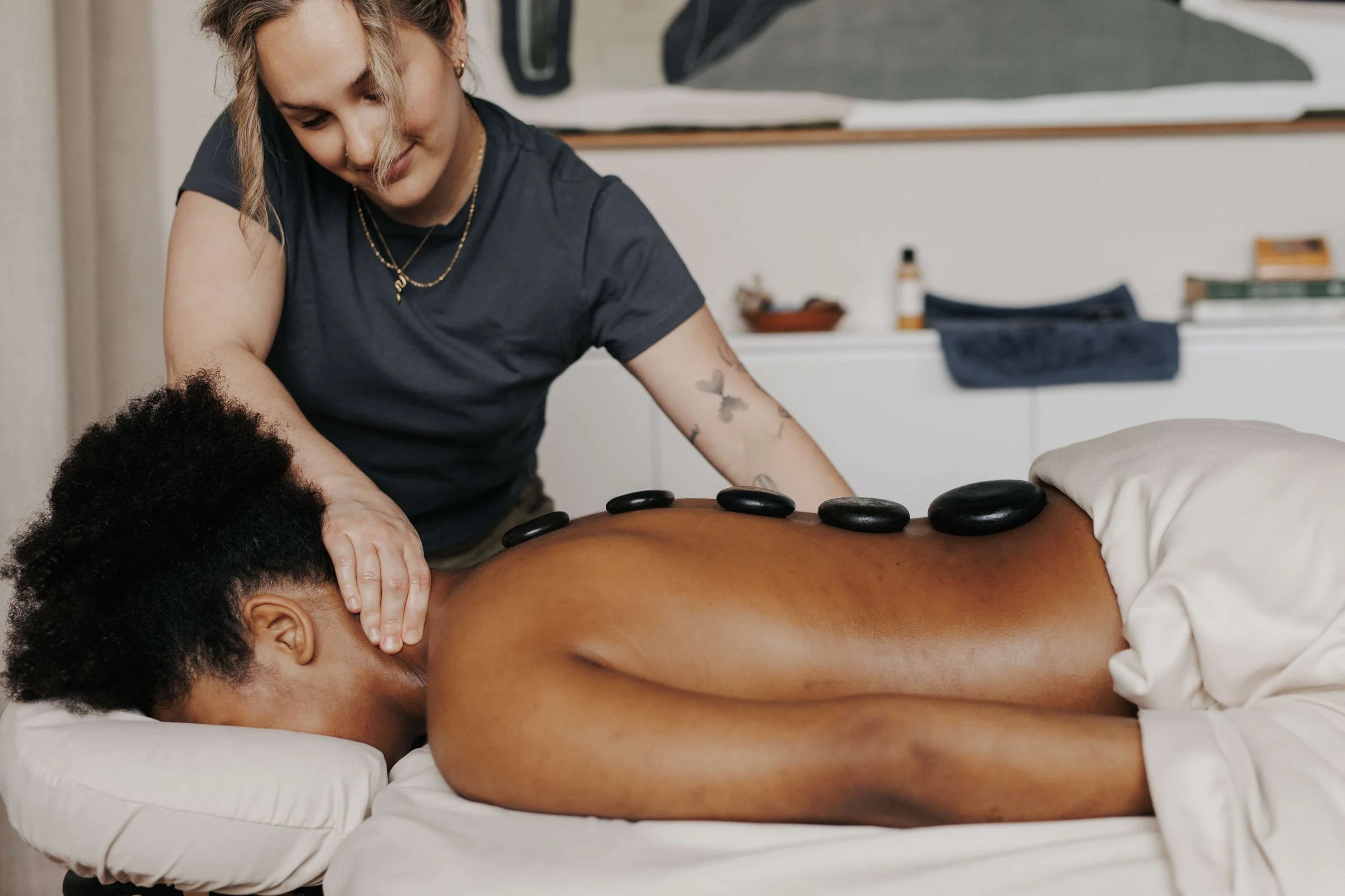 photo of kaitlin lane from interbeing bodywork massaging someone with hot stones