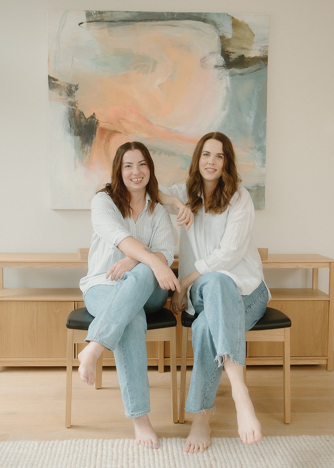 Isobel Griffin and Samara Bortz sitting in front of a painting