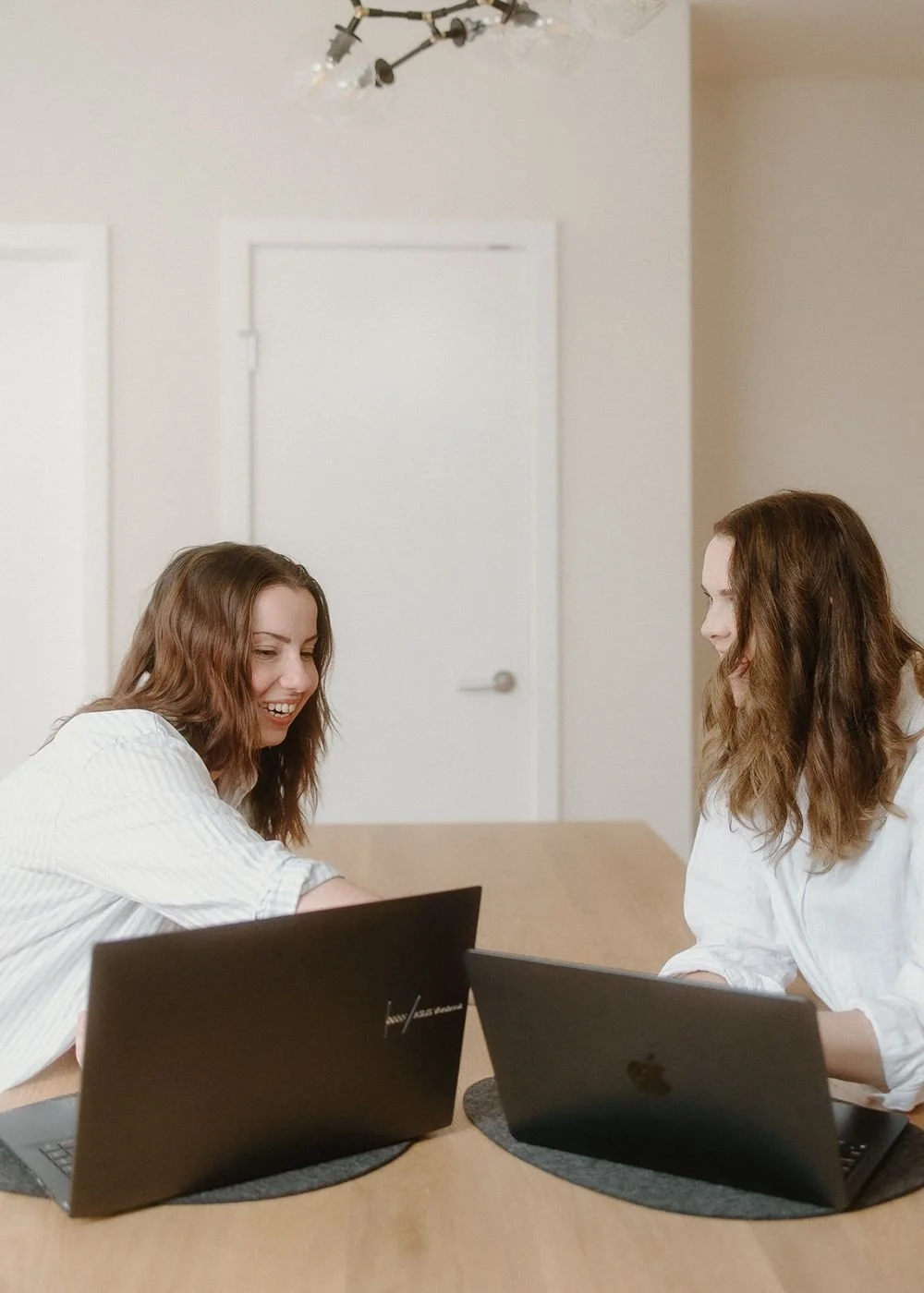 isobel griffin and samara bortz from in tandem studios coworking on laptops