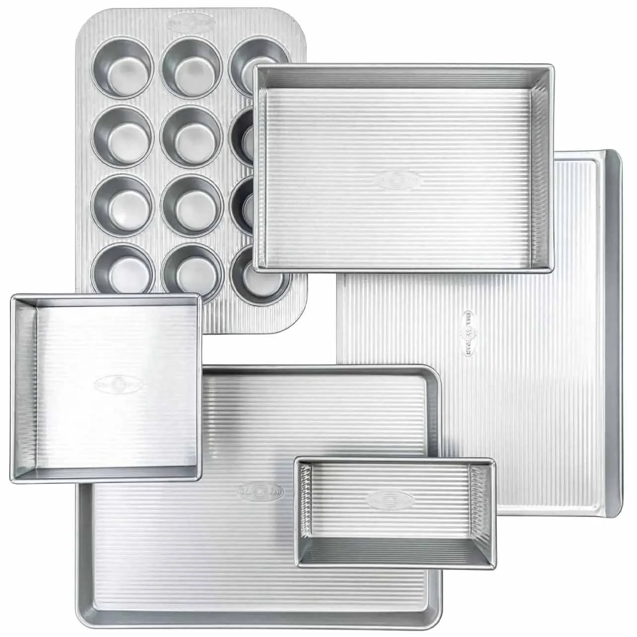 Set of various aluminum baking pans including a muffin tin, loaf pans, sheet pans, and baking trays.