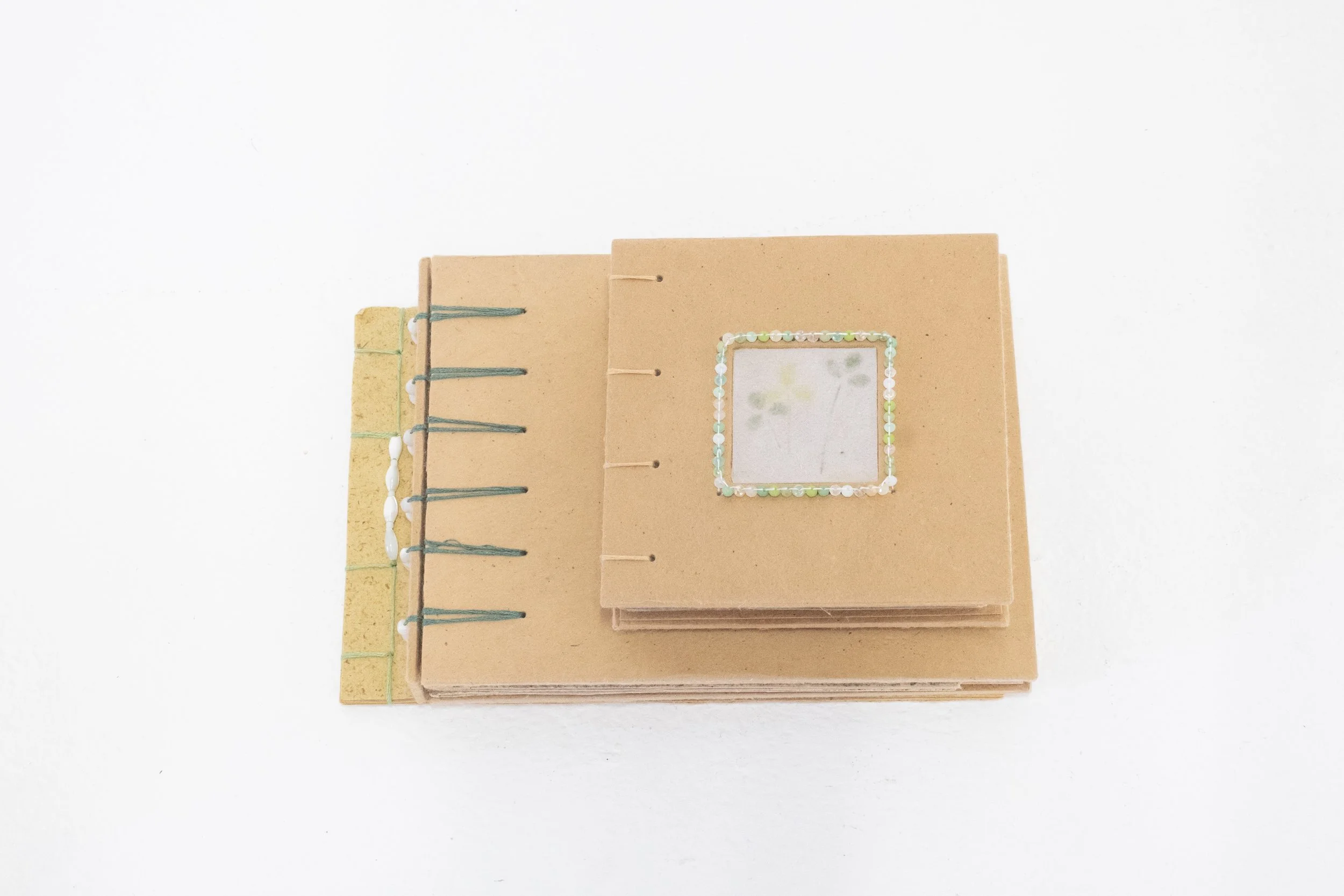 three books bound with handmade marigold, tango cosmos, and coreopsis petal papers