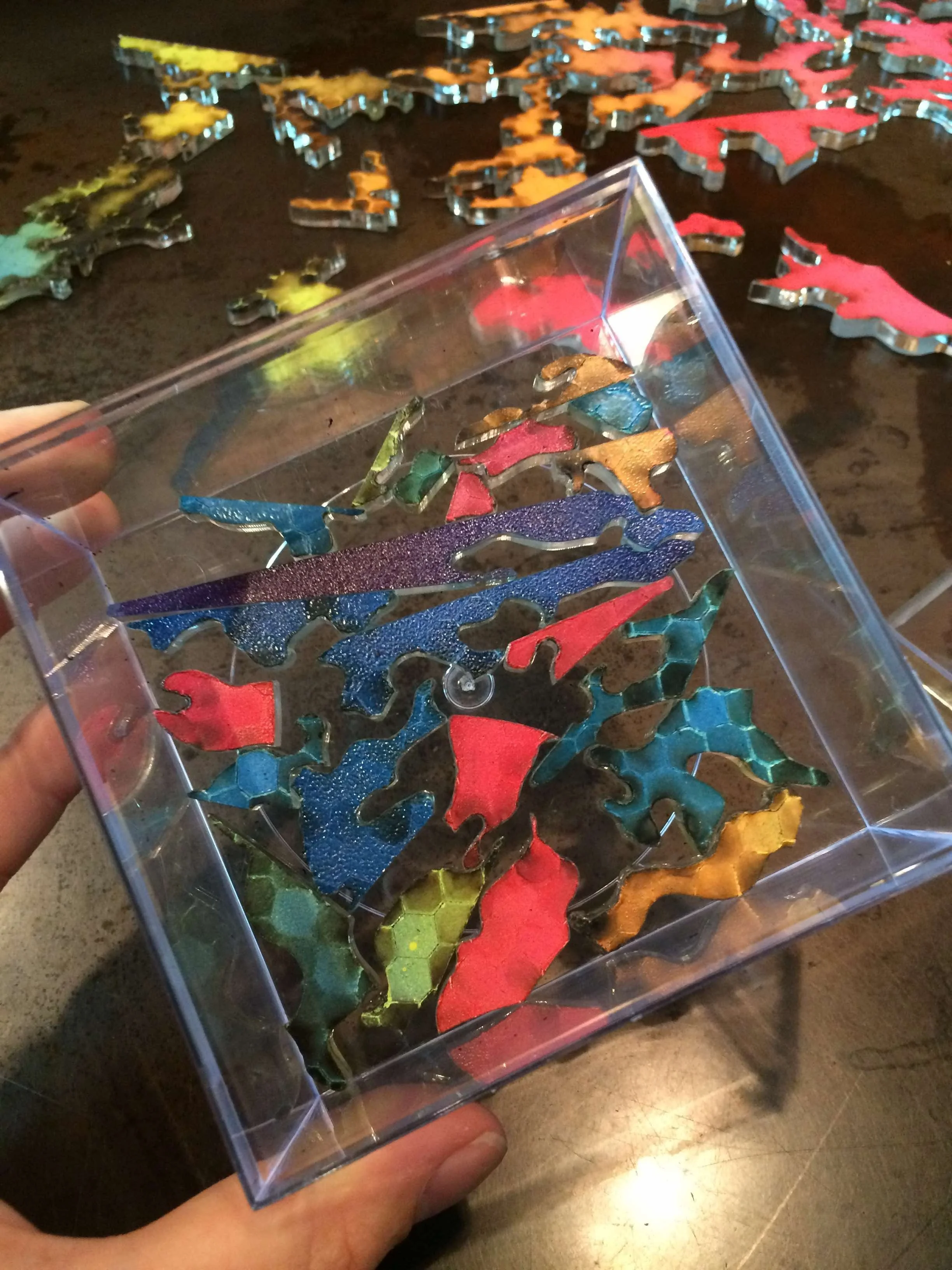 red orange yellow and blue acrylic nike swoosh puzzle pieces scattered across black table