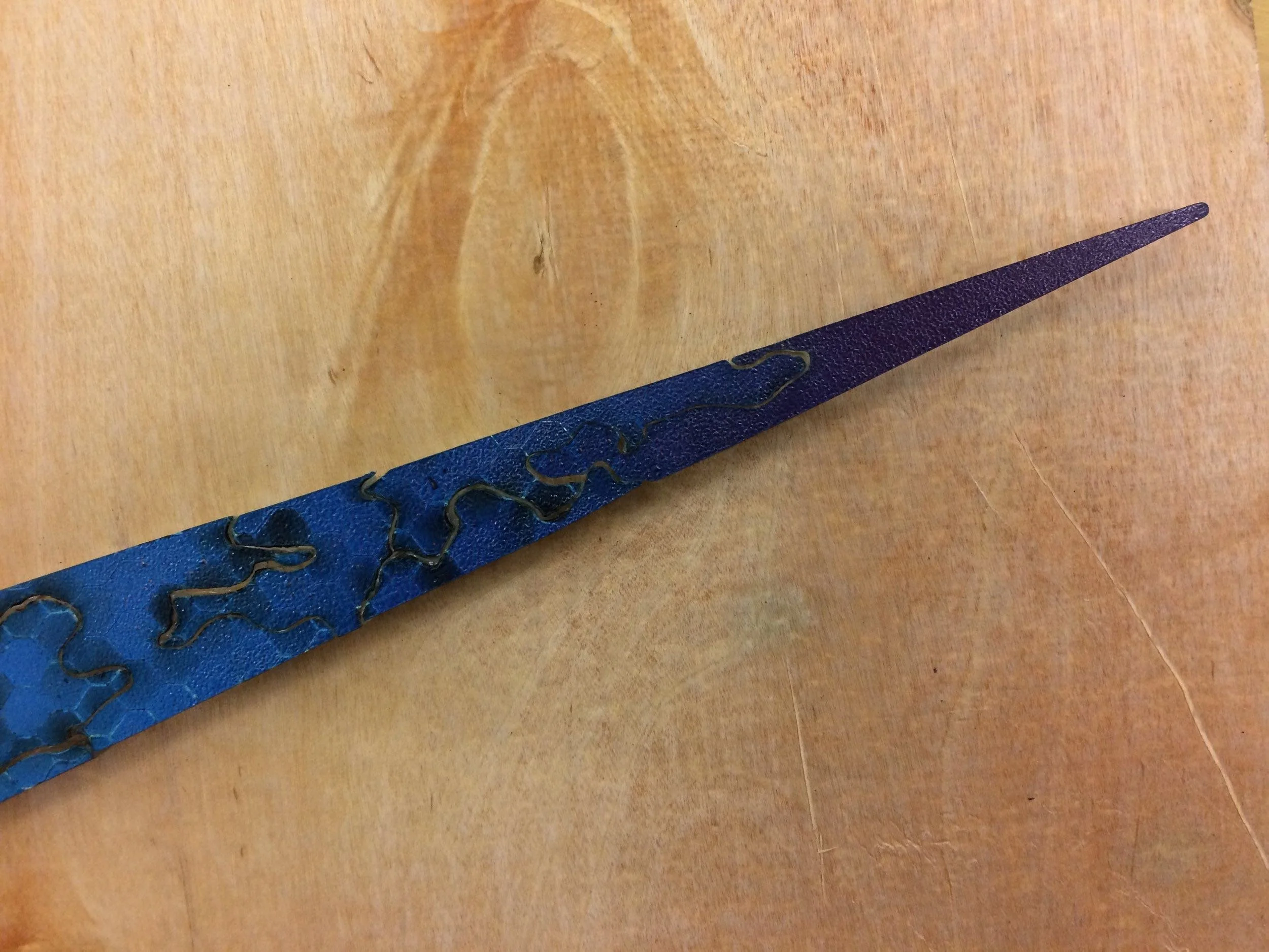 Thin toip of blue nike swoosh acrylic puzzle on brown wood table