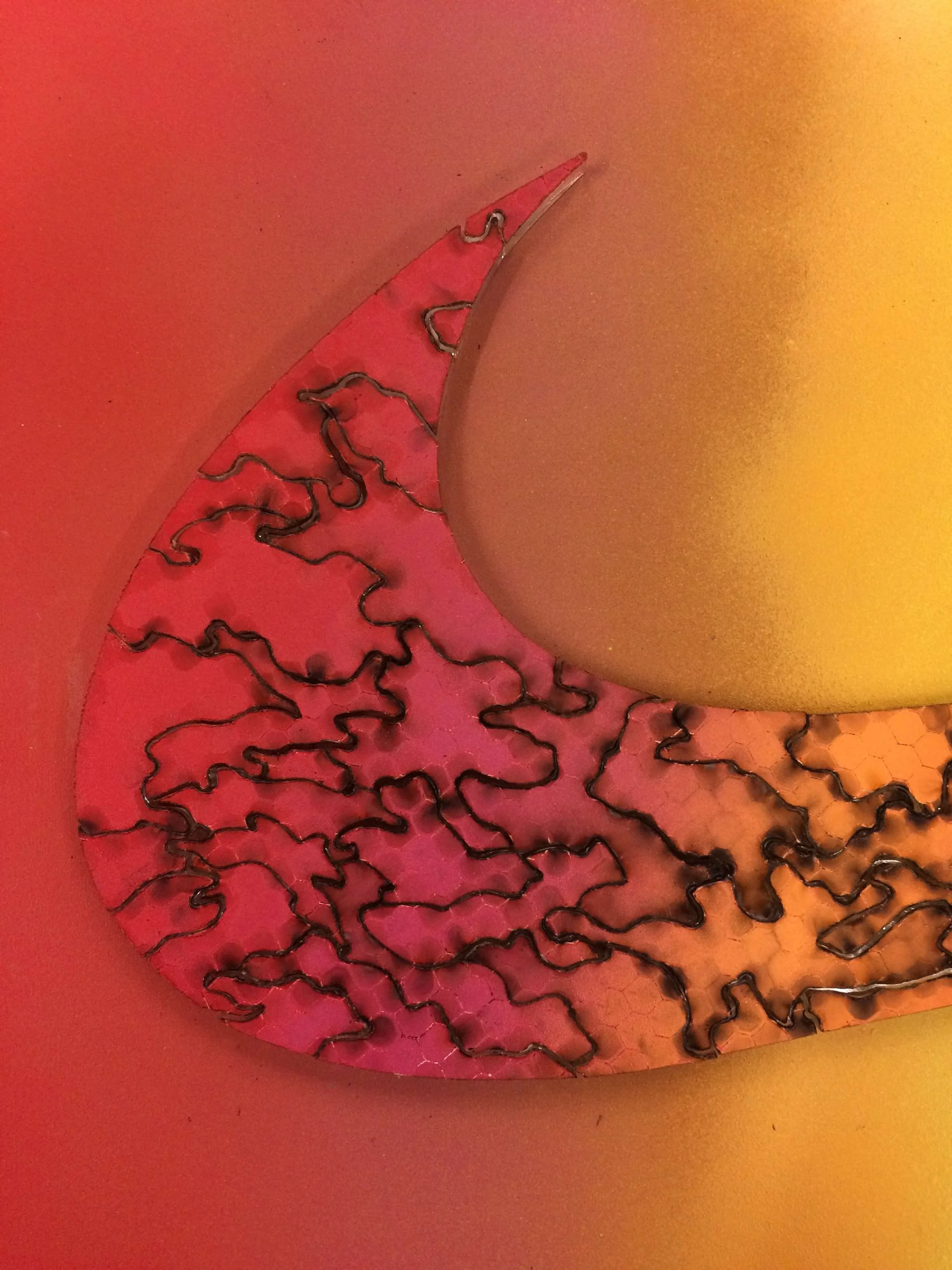 Curved side of nike swoosh acrylic puzzle on red and yellow gradient background