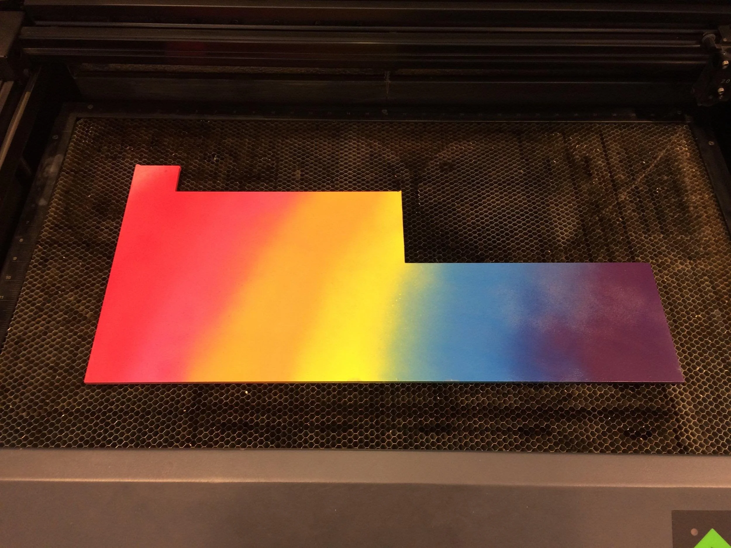 Spraypainted acrylic material for nike swoosh puzzle sculpture on black metal grate