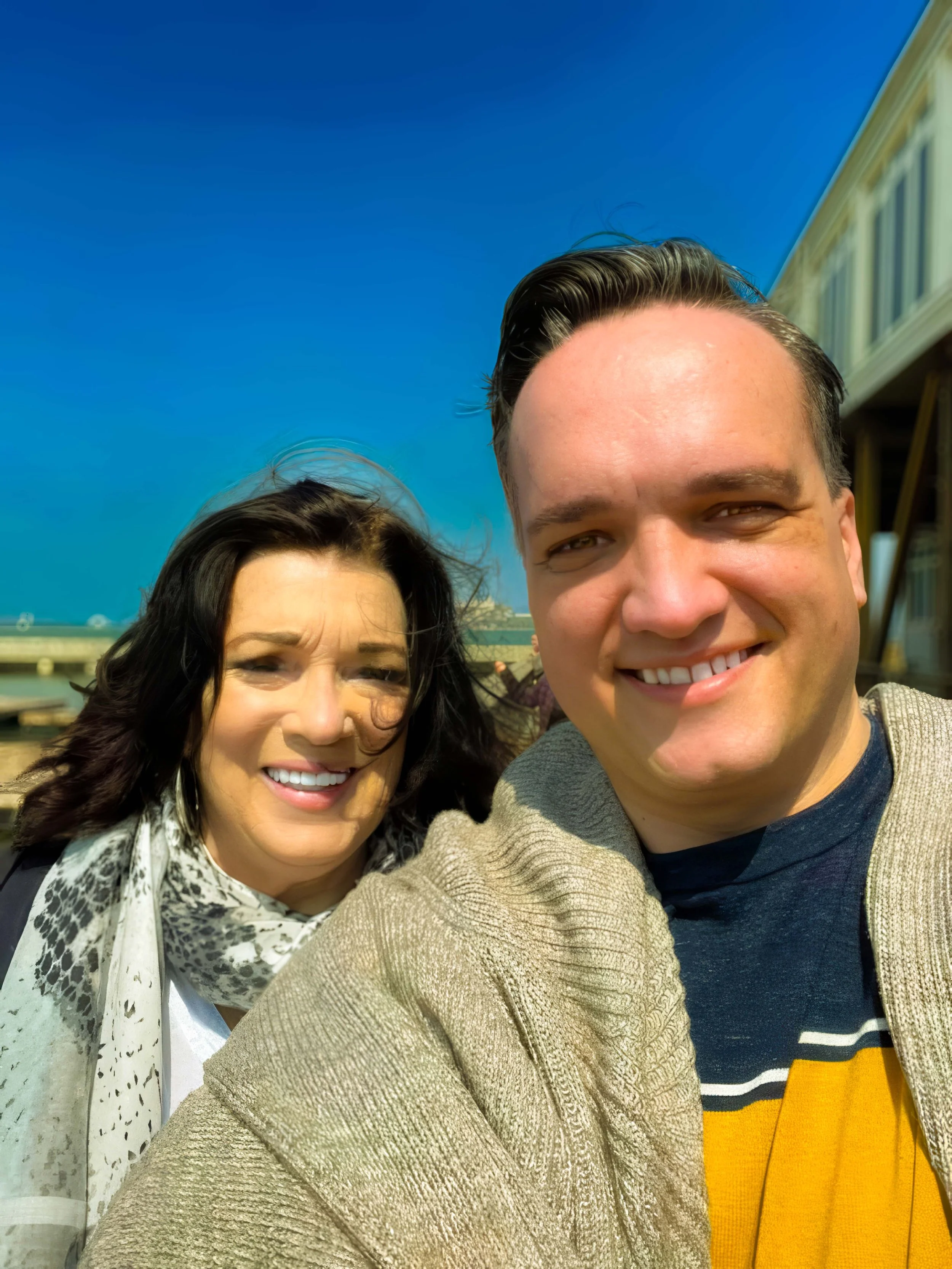 Caleb and Robyn smiling outdoors on a sunny day, wearing casual attire and enjoying the moment. Independent film documentary creators taking a break.”
