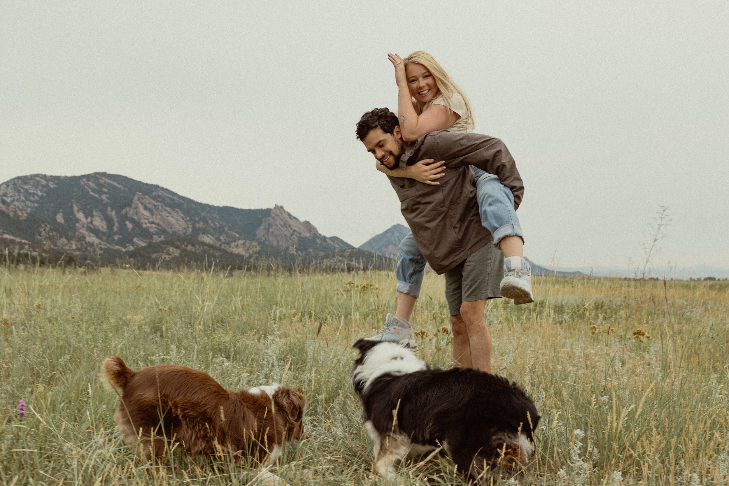 A personable family. The woman is a chef that cooks in-home meals for families and busy professionals in Boulder, Colorado. The photo features australian shepherds, Boulder's iconic Flatirons and a lot of love.
