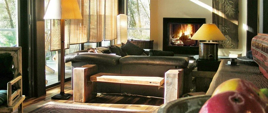 Bridge House living area with leather sofas, a propane fireplace with the openness and expansive windows of modern west coast architecture.