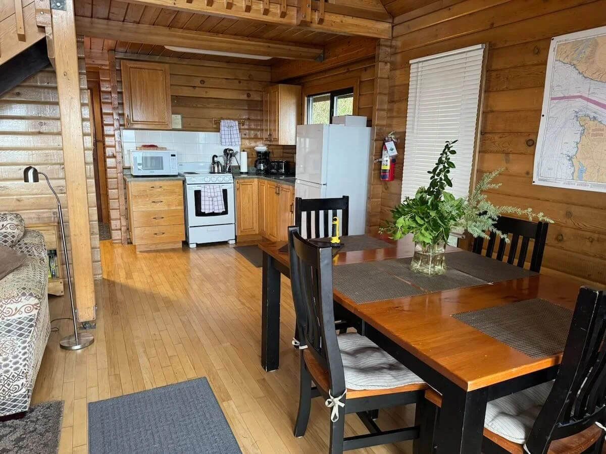 Cabin A's kitchen and dining area with wooden walls and flooring.