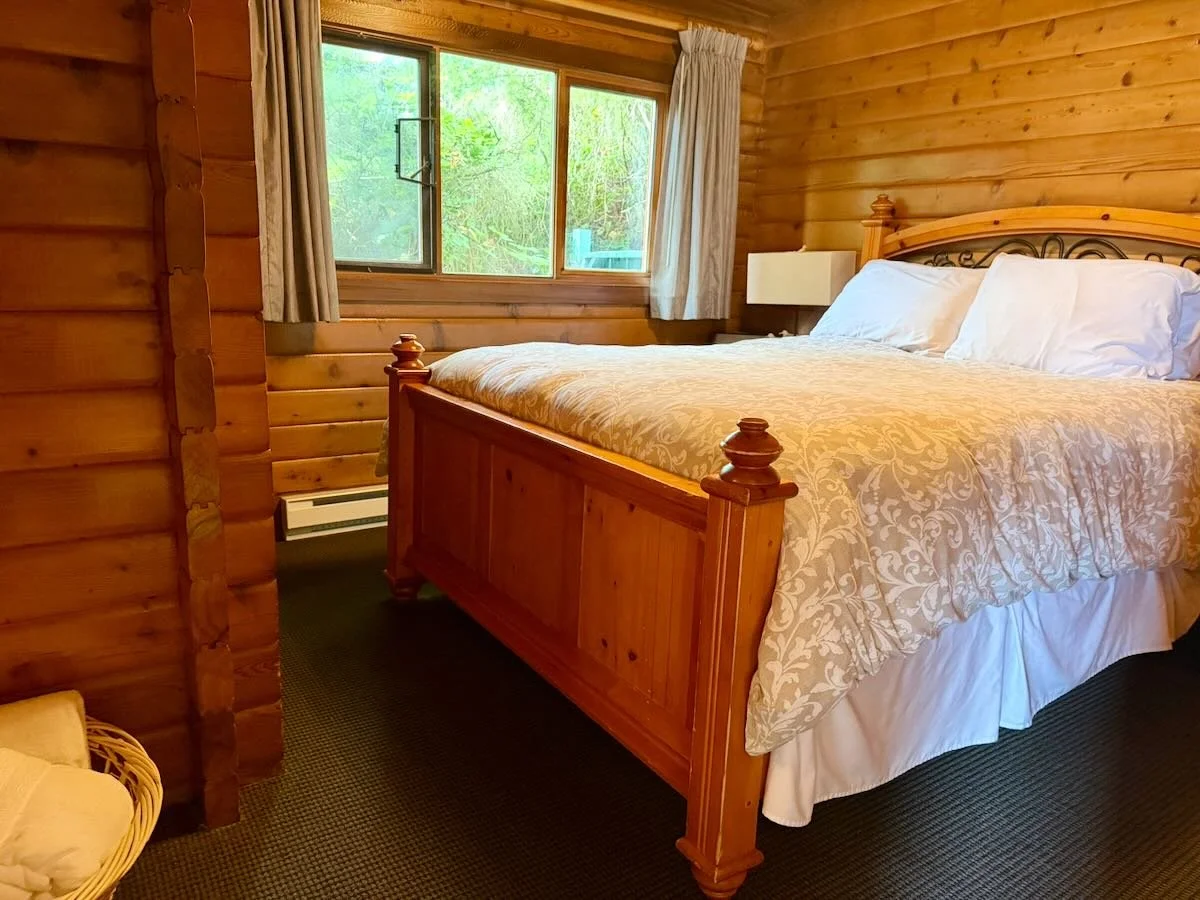 Cabin 10 bedroom has a queen-sized bed, featuring a large window with curtains.